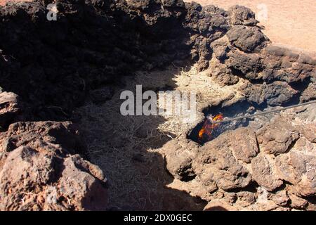 Flammes provenant du cratère volcanique dans le parc national de Timanfaya, îles Canaries. Foin brûlant dans le sol dans l'attraction touristique de Lanzarote. Geother Banque D'Images