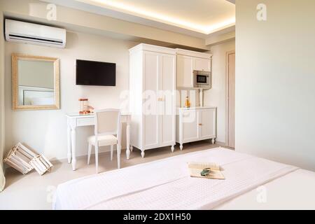 Intérieur blanc élégant d'une petite chambre studio avec mobilier classique en bois dans l'appartement moderne de l'hôtel. Banque D'Images