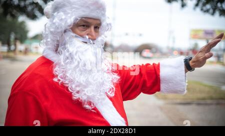 Bossier City, Louisiane, États-Unis. 23 décembre 2020. Le lieutenant-colonel Mark Geer de la U.S. Air Force, directeur du personnel de la 2e Escadre Bomb, célèbre l'esprit des fêtes en portant un costume de Santa tout en agitant les passants à la porte de la base aérienne de Barksdale le 23 décembre 2020 à Bossier City, en Louisiane. Credit: Planetpix/Alamy Live News Banque D'Images