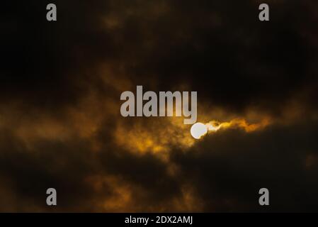 le soleil se cache derrière des nuages sombres essayant de se laisser dehors ses rayons chauds et lumineux du soleil à donnez de l'énergie à tout ce qui vit sur terre Banque D'Images
