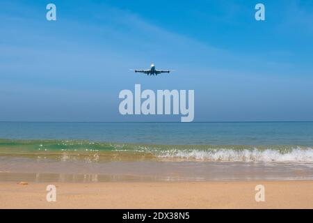 L'avion survole la plage de Mai Khao en thaïlande. Ci-dessous se trouve un sable doux et une mer bleue avec de belles vagues. Banque D'Images