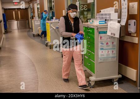 Roseville, Californie, États-Unis. 22 décembre 2020. Jennifer Traylor, assistante de laboratoire phlebotomiste, tire des gants alors qu'elle descend le couloir de triage à l'intérieur du service des urgences pour prendre soin des patients positifs au COVID-19 au centre médical Sutter Roseville le mardi 22 décembre 2020. Crédit : Renée C. Byer/ZUMA Wire/Alay Live News Banque D'Images