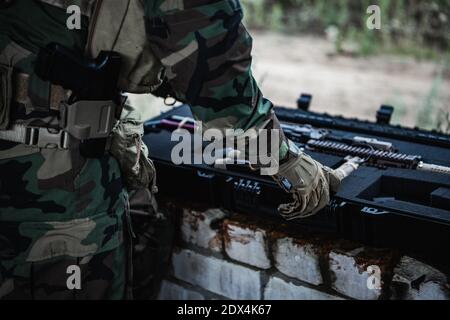 Militaire préparant l'équipement des armes à feu à la mission. Sort le fusil d'assaut de la boîte à munitions. Banque D'Images