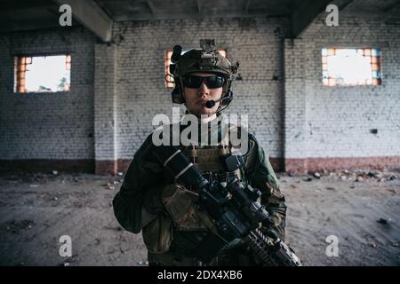 Gros plan d'un soldat professionnel entièrement équipé regardant la caméra. Banque D'Images