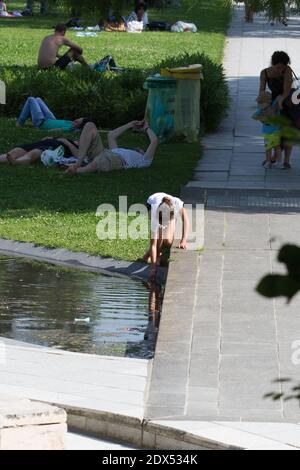 S'il vous plaît cacher le visage des enfants avant la publication - les personnes essayant de trouver un peu de fraîcheur dans le Parc André Citroen, à Paris, le 18 juillet 2014. Photo d'Edouard Grandjean/ABACAPRESS.COM Banque D'Images