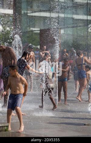 S'il vous plaît cacher le visage des enfants avant la publication - les personnes essayant de trouver un peu de fraîcheur dans le Parc André Citroen, à Paris, le 18 juillet 2014. Photo d'Edouard Grandjean/ABACAPRESS.COM Banque D'Images