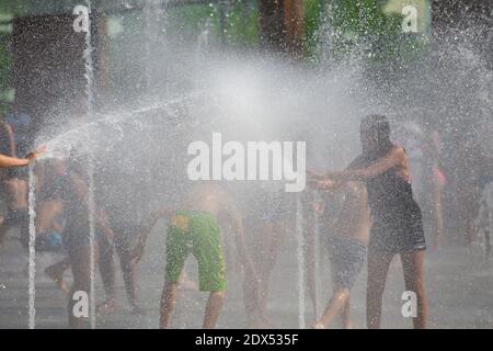 S'il vous plaît cacher le visage des enfants avant la publication - les personnes essayant de trouver un peu de fraîcheur dans le Parc André Citroen, à Paris, le 18 juillet 2014. Photo d'Edouard Grandjean/ABACAPRESS.COM Banque D'Images