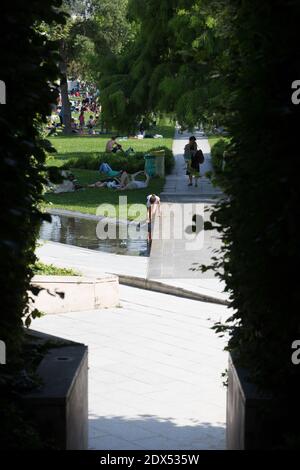 S'il vous plaît cacher le visage des enfants avant la publication - les personnes essayant de trouver un peu de fraîcheur dans le Parc André Citroen, à Paris, le 18 juillet 2014. Photo d'Edouard Grandjean/ABACAPRESS.COM Banque D'Images