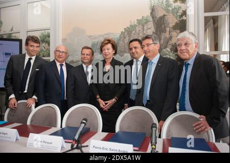 Ministre français de l'économie Arnaud Montebourg, ministre français des Finances Michel Sapin, directeur des solutions financières et commerciales, membre du comité directeur général de Natixis Olivier Perquel, commissaire européen à l'agenda numérique Neelie Kroes, Pierre-Eric Saint-André, président d'Axione infrastructure, Philippe de Fontaine vive Curtaz, vice-président de la Banque européenne d'investissement (BEI), et Pierre-Rene Lemas, président de la banque d'investissement publique française « la Caisse des dépôts » (CDC), posent avant la signature de la première obligation européenne « Project Bond » sur les infrastructures numériques à Paris, en France, le 23 juillet 2014 Banque D'Images