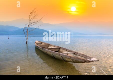 Bateau de pêche dans le grand lagon au coucher du soleil. C'est le principal moyen de transport pour pêcher des poissons dans le centre du Vietnam Banque D'Images