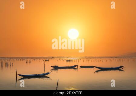 Bateau de pêche dans le grand lagon au coucher du soleil. C'est le principal moyen de transport pour pêcher des poissons dans le centre du Vietnam Banque D'Images