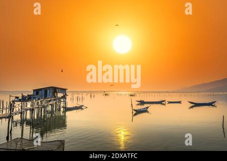 Bateau de pêche dans le grand lagon au coucher du soleil. C'est le principal moyen de transport pour pêcher des poissons dans le centre du Vietnam Banque D'Images