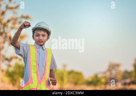 Garçon enfant Ingénieur debout extérieur main de retenue de succès concept Banque D'Images