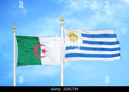 Algérie et Uruguay deux drapeaux sur les mâts et le ciel bleu Banque D'Images