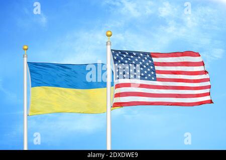 Ukraine et États-Unis deux drapeaux sur les mâts de drapeaux et bleu ciel Banque D'Images