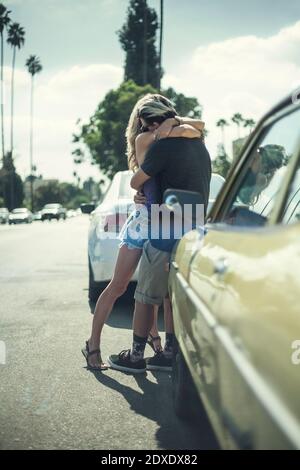 Un couple affectueux s'embrassant en voiture d'époque dans la rue Banque D'Images