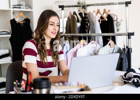 Femme design professionnel travaillant sur ordinateur portable en studio Banque D'Images