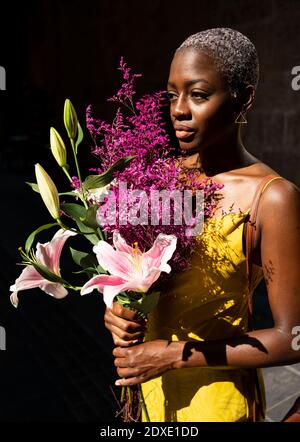 Boxer féminin plein d'assurance avec bouquet de fleurs par beau temps Banque D'Images