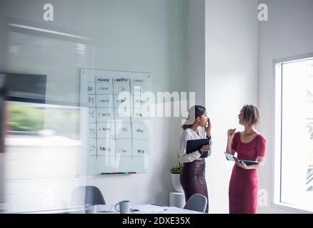 Femme entrepreneur avec collègue discutant pendant qu'elle est au bureau Banque D'Images