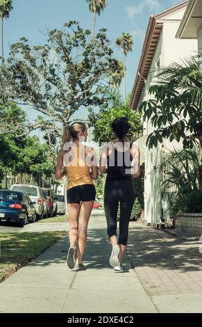 Des amis multiethniques baladent dans les rues par beau temps Banque D'Images