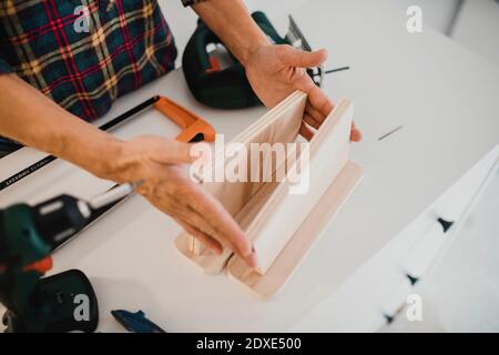 Femme mesurant le bois tout en faisant du bricolage à la maison Banque D'Images