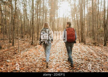 Jeune couple randonnée avec sacs à dos dans la forêt d'automne Banque D'Images