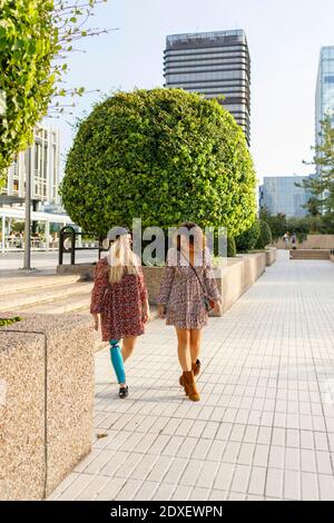 Femme handicapée marchant avec une amie sur le sentier de la ville Banque D'Images