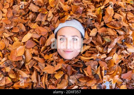 Magnifique visage de femme entouré de feuilles d'automne à Cannock Chase bois Banque D'Images