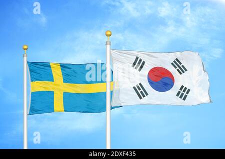 La Suède et la Corée du Sud deux drapeaux sur les mâts de drapeaux et le bleu ciel Banque D'Images