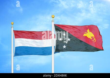 Pays-Bas et Papouasie-Nouvelle-Guinée deux drapeaux sur les mâts de drapeaux et ciel bleu Banque D'Images