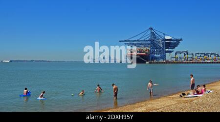 Felixstowe docks bateau conteneur chargé avec des jeunes ayant une baignade dans le forground. Banque D'Images