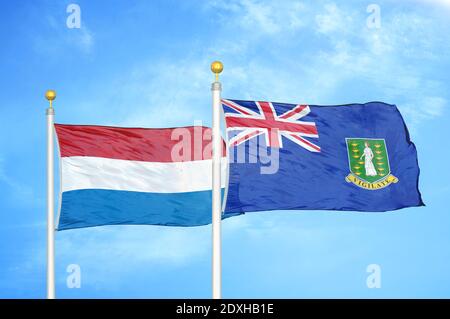Pays-Bas et îles Vierges britanniques deux drapeaux sur les mâts de drapeau et ciel bleu Banque D'Images