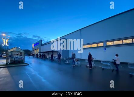 Berlin, Allemagne. 24 décembre 2020. Les gens font la queue à l'extérieur d'une succursale d'une chaîne de supermarchés pour faire leurs achats de Noël. Credit: Paul Zinken/dpa/Alay Live News Banque D'Images