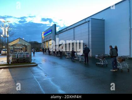 Berlin, Allemagne. 24 décembre 2020. Les gens font la queue à l'extérieur d'une succursale d'une chaîne de supermarchés pour faire leurs achats de Noël. Credit: Paul Zinken/dpa/Alay Live News Banque D'Images