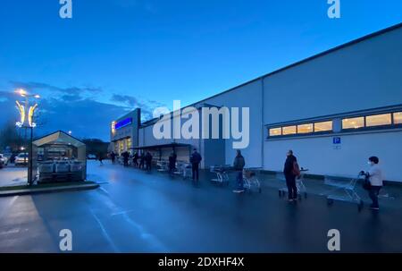 Berlin, Allemagne. 24 décembre 2020. Les gens font la queue à l'extérieur d'une succursale d'une chaîne de supermarchés pour faire leurs achats de Noël. Credit: Paul Zinken/dpa/Alay Live News Banque D'Images