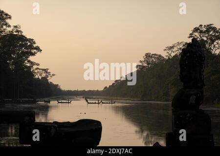 Bateaux traversant la rivière près d'Angkor Wat Banque D'Images