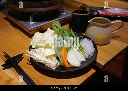 Ensemble de légumes frais mélangés, riz, œufs biologiques crus et soupe miso préparés pour Sukiyaki (Hot pot japonais) Banque D'Images