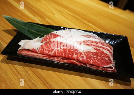 Bœuf Wagyu japonais en tranches frais et cru décoré de noir plaque en céramique Banque D'Images