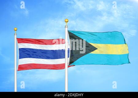 Thaïlande et Bahamas deux drapeaux sur les mâts et le ciel bleu Banque D'Images