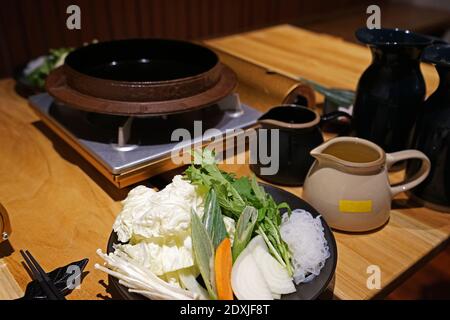 Ensemble de légumes frais mélangés, riz, œufs biologiques crus et soupe miso préparés pour Sukiyaki (Hot pot japonais) Banque D'Images