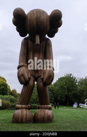 LONDRES, ROYAUME-UNI - 18 octobre 2014 : la sculpture en bois de petit mensonge de KAWS à l'exposition d'art Frieze à Regents Park. Banque D'Images