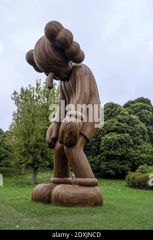 LONDRES, ROYAUME-UNI - 18 octobre 2014 : la sculpture en bois de petit mensonge de KAWS à l'exposition d'art Frieze à Regents Park. Banque D'Images