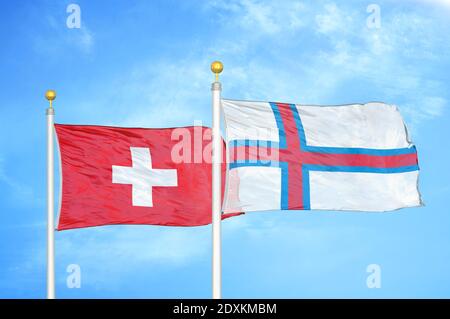 La Suisse et les îles Féroé deux drapeaux sur les mâts et le bleu ciel Banque D'Images