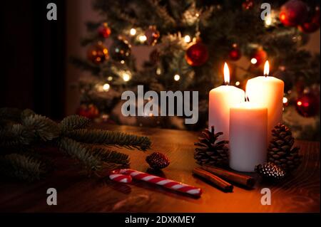 Bougie brûlante et décorations de Noël contre l'arbre de Noël Banque D'Images