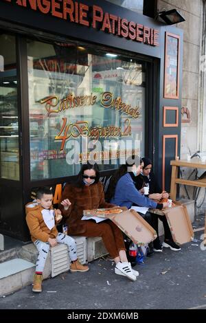 22 décembre 2020 : Marseille, France. 22 décembre 2020. Les membres de la même famille mangent de la pizza à l'extérieur d'une boulangerie et d'une pâtisserie dans la ville française de Marseille. La France a levé un verrouillage le 15 décembre, mais les bars, les restaurants et les cafés doivent rester ouverts uniquement pour les magasins jusqu'au 20 janvier au moins crédit: Louai Barakat/IMAGESLIVE/ZUMA Wire/Alay Live News Banque D'Images