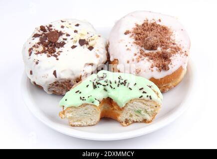 Deux donuts et demi sur une assiette blanche Banque D'Images