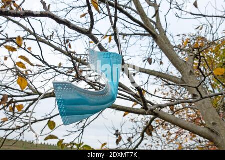 Masque de visage suspendu sur l'arbre en automne Banque D'Images