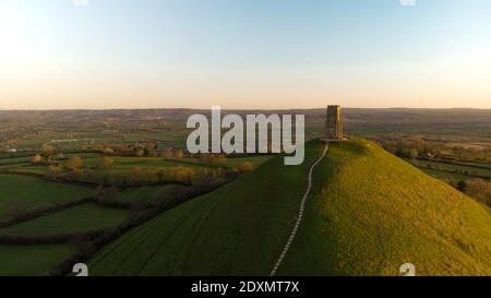 Vue aérienne du lever du soleil tôt le matin au-dessus de Glastonbury Tor avec les champs Somerset ci-dessous. Banque D'Images