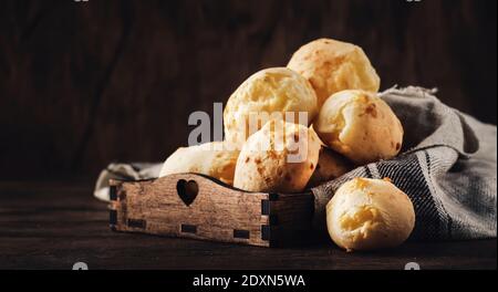 Petits pains au fromage doré sur plateau en bois, table de cuisine rustique, espace de photocopie Banque D'Images