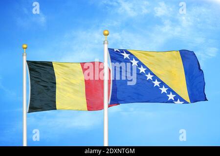 Belgique et Bosnie-Herzégovine deux drapeaux sur les mâts de drapeaux et ciel bleu nuageux Banque D'Images